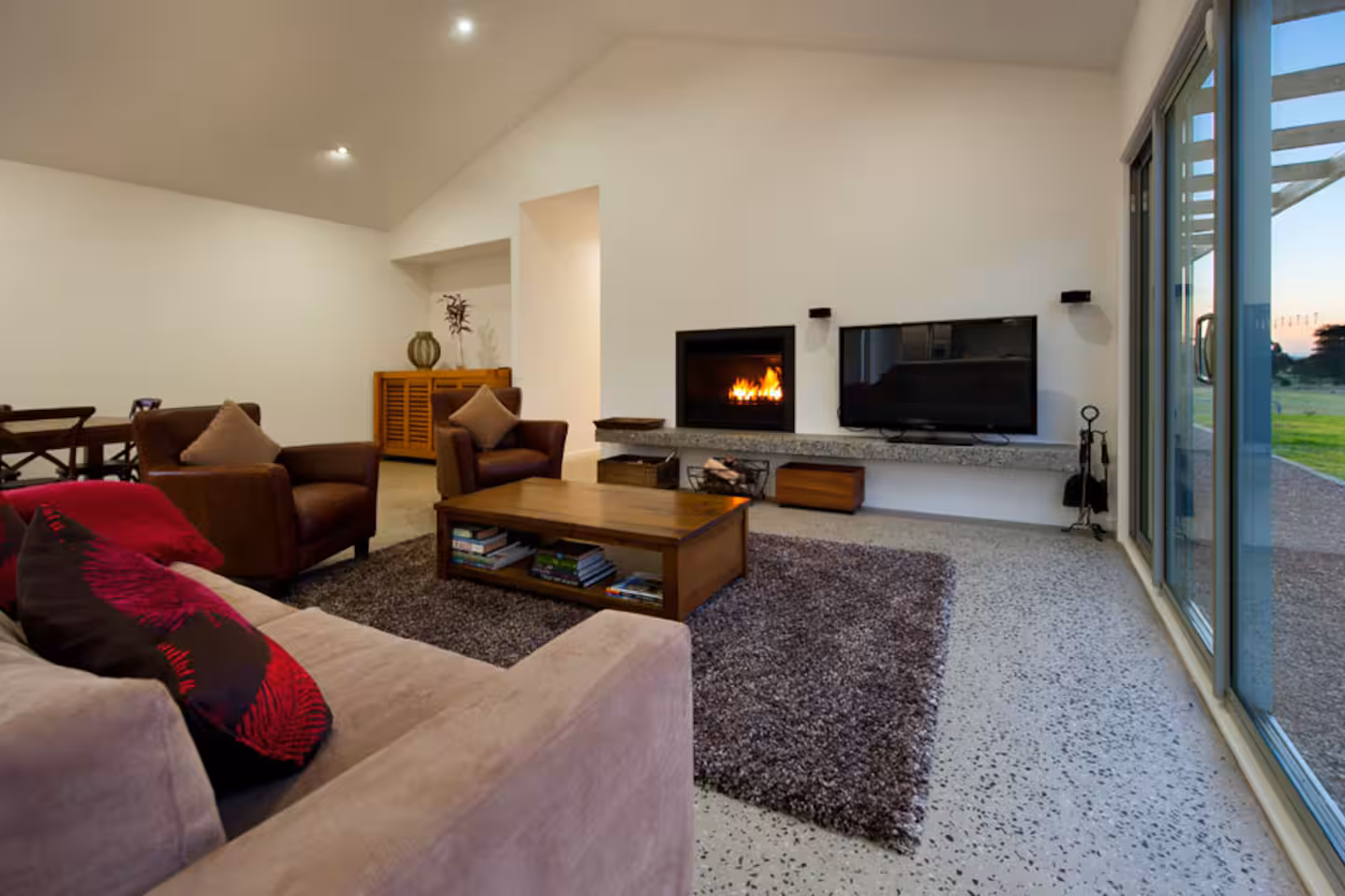 Open fireplace and lounge with polished concrete floors and rural views